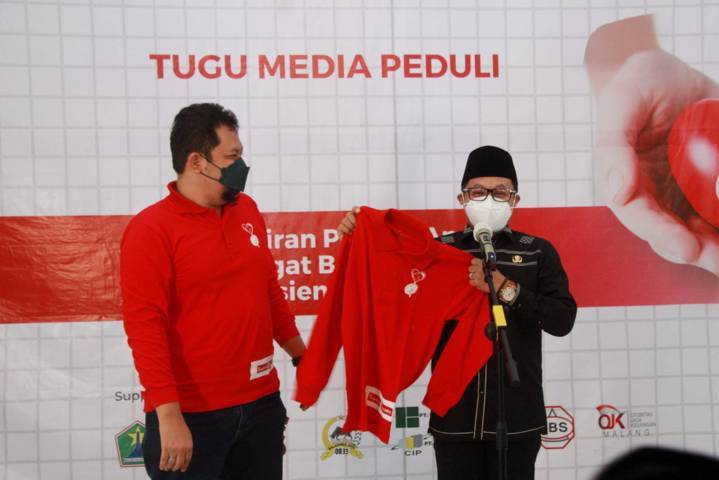 CEO Tugu Media Group Irham Thoriq memberikan kaus kepada Wali Kota Malang Sutiaji saat donor plasma konvalesen yang digagas Tugu Media Group di Aula Kantor DPRD Kota Malang pada Kamis (12/08/2021). (Foto: Rubianto/Tugu Jatim)