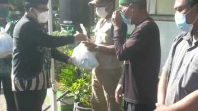 Kepala Kantor Kemenag Tuban Sahid menyerahkan paket sembako dan vitamin untuk warga terdampak Covid-19 di sekitar KUA Semanding, Kamis (12/08/2021). (Foto: Humas Kemenag Tuban/Tugu Jatim)