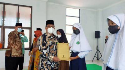 Kepala Kantor Kemenag Kabupaten Tuban Sahid menyerahkan santunan kepada anak yatim saat memperingati 1 Muharram pada Jumat (20/08/2021). (Foto: Humas Kemenag Tuban/Tugu Jatim)