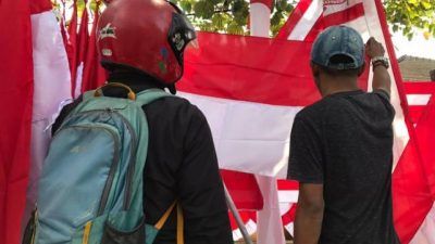 Salah seorang calon pembeli bendera menanyakan pada salah satu penjual bendera di Sawojajar, Kota Malang, Selasa (3/7/2021). (Foto: Rizal Adhi/Tugu Malang/Tugu Jatim)