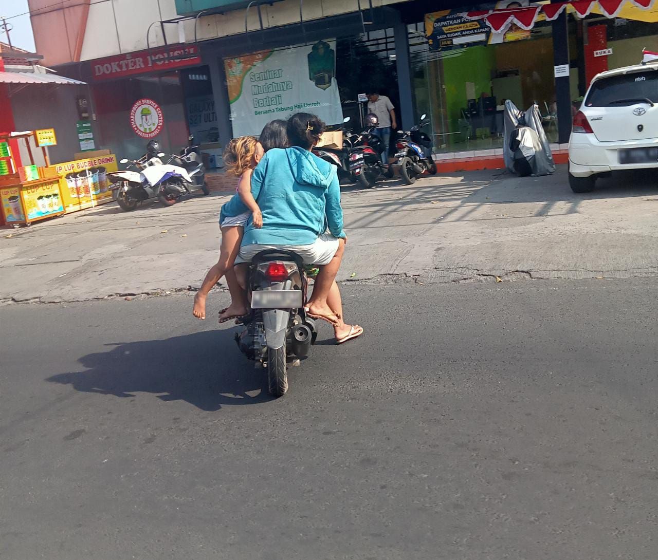 Sepeda motor melintas di Jalan Ranu Grati, Kota Malang, Rabu siang (24/8). Sepeda motor tersebut dinaiki 4 orang. Dua orang dewasa, yang tampaknya pasangan suami istri/tugu jatim