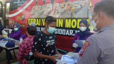 Polresta Sidoarjo menggelar vaksinasi massal untuk pelaku UMKM di wilayah kavling DPR Desa Pagerwojo, Buduran, Sidoarjo, pada Jumat (13/08/2021). (Foto: Dimas Ari S./Tugu Jatim)