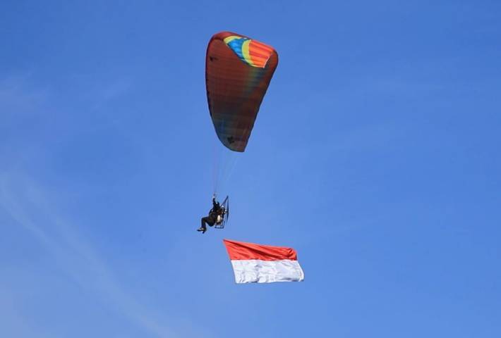 Rayakan Kemerdekaan RI ke-76, atlet paramotor Kota Batu kibarkan bendera Merah Putih di langit Kota Batu, Selasa (17/08/2021). (Foto: Istimewa/Tugu Jatim)