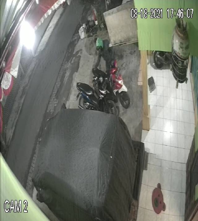 Rekaman CCTV menunjukkan seorang pria berhelm ojol tengah beraksi mencuri motor pada Rabu (18/08/2021). (Foto: tangkapan layar CCTV/Tugu Jatim)