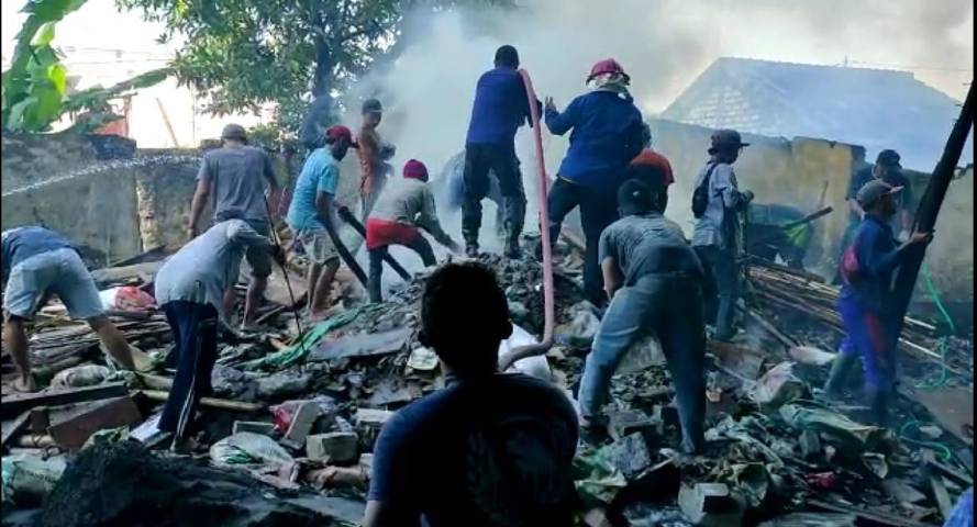 Petugas pemadam kebakaran dari BPBD Tuban bersama warga saat berada di tengah kepungan asap tebal akibat kebakaran kayu material proyek hotel di Tuban, Minggu (1/8/2021). (Foto: Humas BPDB Tuban) tugu jatim
