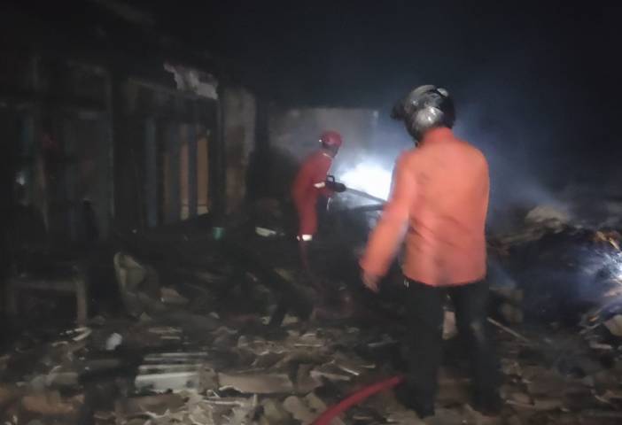 Upaya pemadaman api yang dilakukan oleh petugas pemadam kebakaran di rumah dan gudang penyimpanan gabah milik Kasjan (44) warga Dusun Sumber Rahayu, Desa Trantang, Kecamatan Kerek, Kabupaten Tuban, Senin (2/8/2021). (Foto: Humas BPDB Tuban) tugu jatim