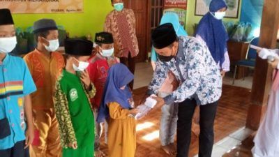 Kepala Desa Sugihan, Kecamatan Merakurak, Kabupaten Tuban, Warsito saat menyantuni anak yatim desa setempat, Kamis (19/8/2021). Kegiatan itu dilakukan sekaligus untuk memeringati bulan di Bulan Muharram. (Foto: Moch Abdurrochim/Tugu Jatim) asyura