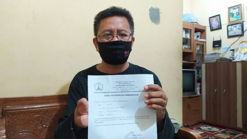 Sunoto (35) saat menunjukkan surat keterangan sehat dari Covid-19. (Foto: M Ulul Azmy/Tugu Malang/Tugu Jatim)