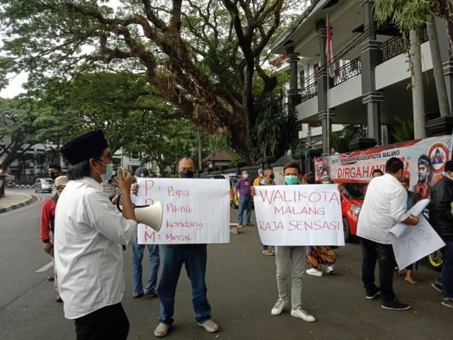 Sejumlah poster tampak dibentangkan oleh aksi massa dari Jaringan Aliansi Aktivis Malang Raya (Jaamara) di depan Balai Kota Malang, Selasa (21/09/2021). (Foto: M. Sholeh/Tugu Malang/Tugu Jatim)