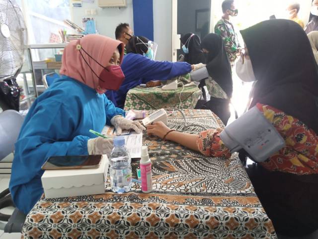 Petugas vaksinator mengecek tekanan darah dari para santri di Tuban. (Foto: Mochamad Abdurrochim/Tugu Jatim)