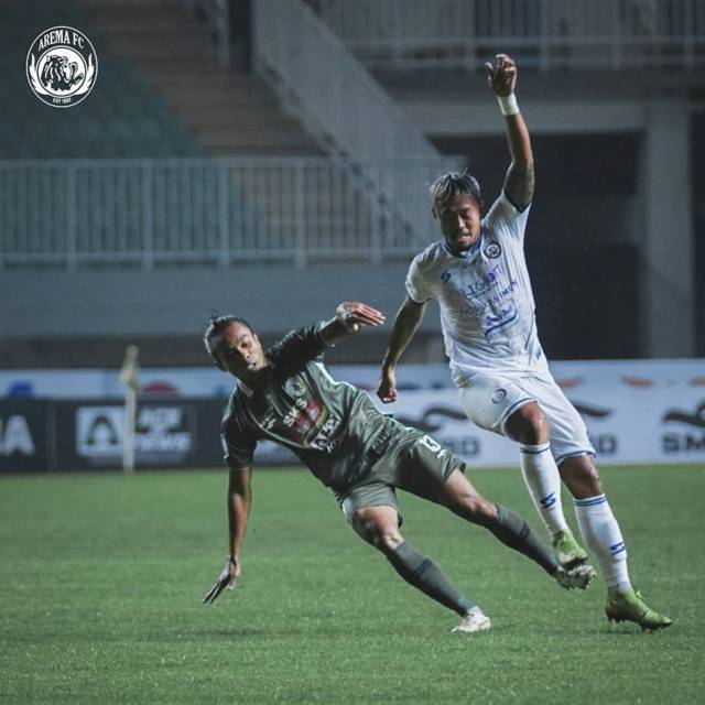 Pemain Arema FC, Kushedya Ari Yudo (jersey putih) sedang berduel dengan pemain PSS Sleman Samsul Arifin (hijau) pada laga lanjutan Liga 1 di Stadion Pakansari, Bogor, Minggu (19/9/2021). (Foto: Instagram/Arema FC Official) tugu jatim