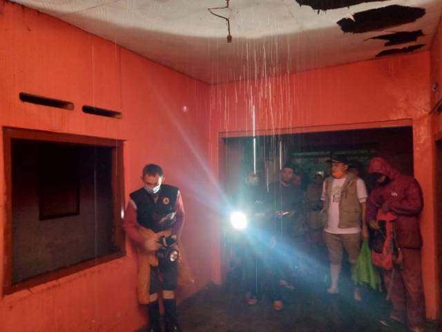 Petugas BPBD Kota Batu saat meninjau atap rumah warga yang jebol akibat guyuran air hujan yang terlalu deras. (Foto: Pusdalops BPBD Kota Batu) tugu jatim