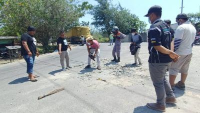 Anggota Forum Biker Tuban (FBT) saat membersihkan limbah tumpahan cor semen yang dianggap membahayakan pengendara motor dengan alat seadanya. (Foto: Dokumen/Forum Biker Tuban) tugu jatim