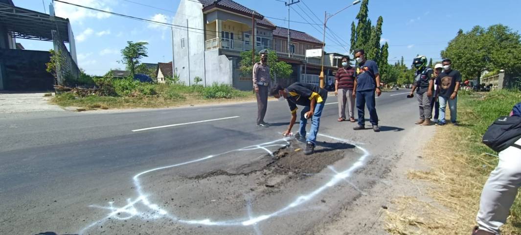 FBT memberikan tanda di sejumlah jalan yang rusak dengan pilox warna putih. (Foto: Dokumen/Forum Biker Tuban) tugu jatim