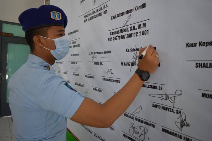 Salah seorang perwakilan petugas Lapas Tuban, menandatangani Deklarasi Perang terhadap Halinar di Aula Lapas Tuban, Kamis (30/9/2021). (Foto: Humas Lapas Tuban) tugu jatim