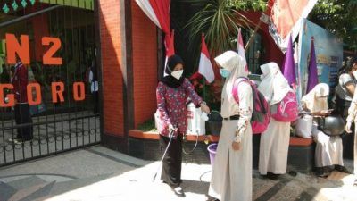 Penyemprotan disinfektan yang dilakukan sebelum memasuki area SMPN 2 Bojonegoro sebagai upaya mencegah klaster Covid-19 di sekolah. (Foto: Mila Arinda / Tugu Jatim) ptm terbatas