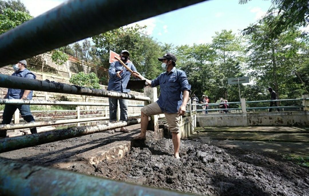 Petugas DLH Kota Batu saat memperbaiki kolam lindi di TPA Tlekung Kota Batu. (Foto: DLH Kota Batu/Tugu Jatim)