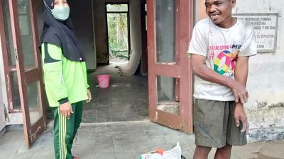 Murwati Handayani, relawan ODGJ, ketika menyambangi Bambang, ODGJ yang tinggal di gedung tua di depan SMAN Punung Kabupaten Pacitan. (Foto: Risma Wigati/Tugu Jatim)