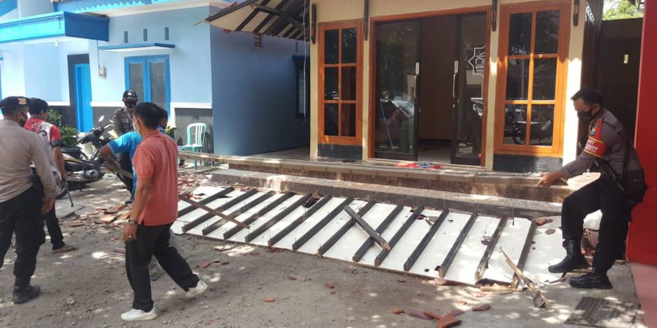 Anggota kepolisian mengangkat puing atap bagian teras gedung musala An Nur di Kecamatan Binangun, Kabupaten Blitar, yang rusak usai gempa bumi M5,1 di barat daya Kabupaten Malang, Jumat (22/10/2021). (BPBD Kabupaten Blitar) gempa malang