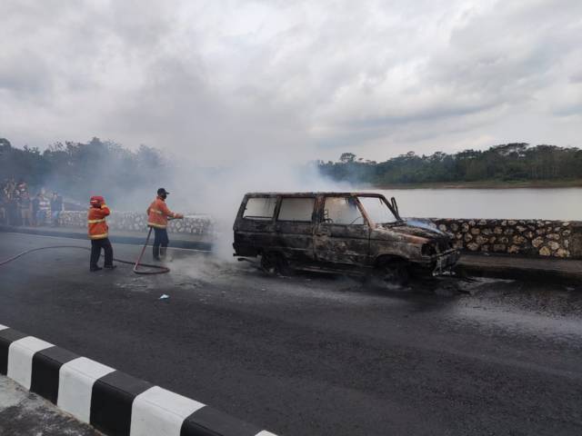 4 mobil damkar dan 9 petugas dikerahkan untuk jinakkan mobil yang terbakar di Bendungan Karangkates, Malang, Minggu (3/10/2021). (Foto: Damkar Kabupaten Malang) tugu jatim kebakaran mobil