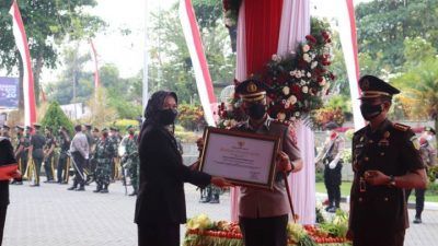 Kapolres Batu AKBP I Nyoman Yogi Hermawan saat menerima penghargaan dari Wali Kota Batu Dewanti Rumpoko atas peran aktifnya dalam percepatan vaksinasi. (Foto: Polres Batu) tugu jatim