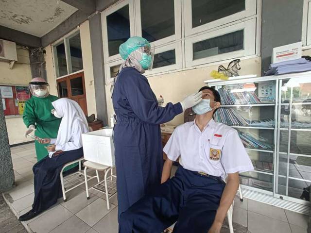 Siswa SMP di Surabaya yang menjalani swab test untuk mengantisipasi penyebaran Covid-19 di sekolah. (Foto: Pemkot Surabaya) tugu jatim