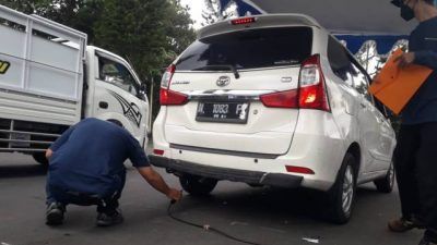 Petugas melakukan uji emisi kendaraan roda 4 di Jalan Simpang Balapan Kota Malang, Selasa (5/10/2021). (Foto: M Sholeh/Tugu Malang/Tugu Jatim)
