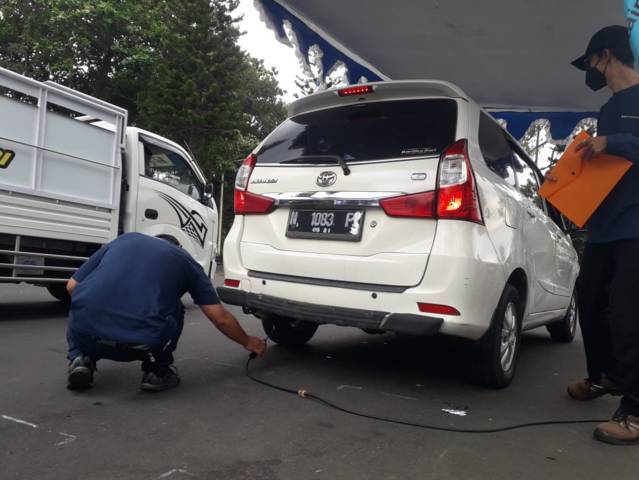 Petugas melakukan uji emisi kendaraan roda 4 di Jalan Simpang Balapan Kota Malang, Selasa (5/10/2021). (Foto: M Sholeh/Tugu Malang/Tugu Jatim)