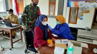 Proses vaksinasi yang dilakukan bidan desa di Balai Desa Pakel, Kecamatan Montong, Kabupaten Tuban. (Foto: Kodim 0811 Tuban) tugu jatim