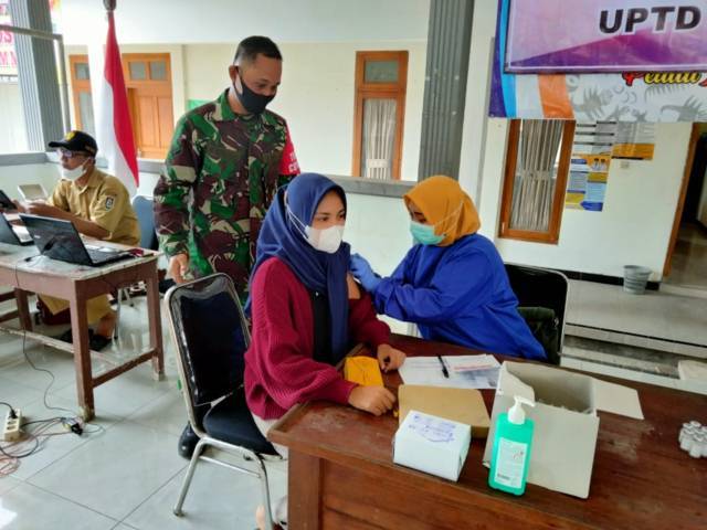 Proses vaksinasi yang dilakukan bidan desa di Balai Desa Pakel, Kecamatan Montong, Kabupaten Tuban. (Foto: Kodim 0811 Tuban) tugu jatim