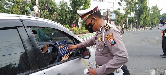 Kanit Kamsel Satlantas Polres Bojonegoro melakukan sosialisasi keselamatan berkendara kepada pengguna jalan. /tugu jatim