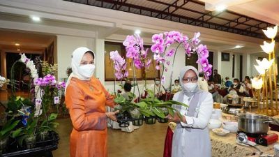 Walikota Batu, Dewanti Rumpoko (kiri), memegang anggrek yang dilelang untuk donasi korban bencana banjir.