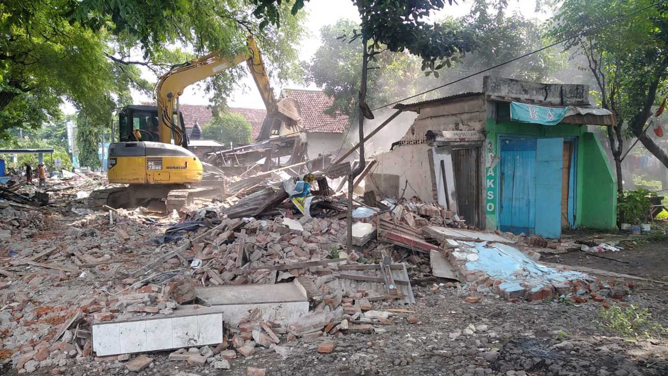 Petugas PT KAI merobohkan bangunan lapak pedagang dengan ekskavator di Stasiun Bangil. (Foto: Humas Daop 8/Tugu Jatim)