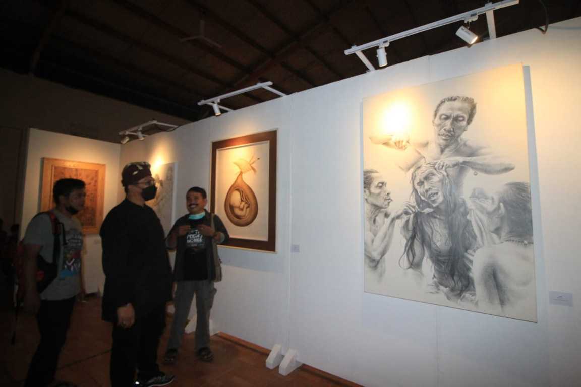 Para pengunjung tampak menikmati pameran lukisan karya Komunitas Guru dan Seniman Pasuruan. (Foto: Laoh Mahfud/Tugu Jatim)