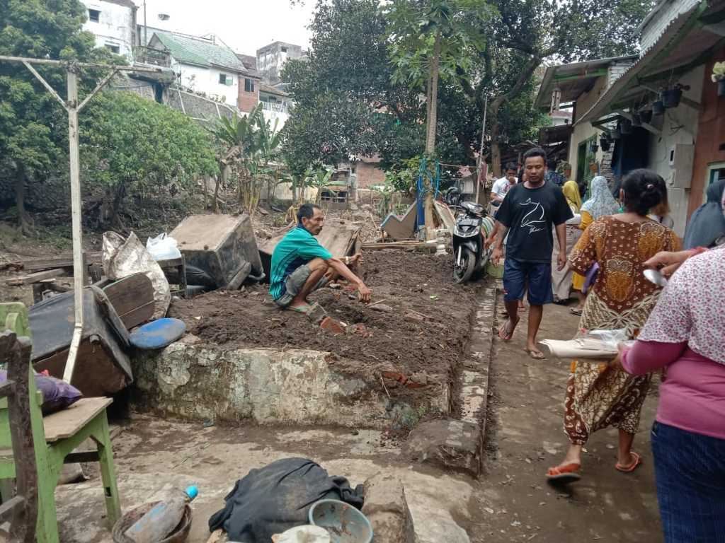 Kini Rohman hanya bisa ngemper di rumah tetangganya karena rumahnya disapu banjir bandang di Kota Malang pada Kamis (04/11/2021). (Foto: M. Sholeh/Tugu Malang/Tugu Jatim)