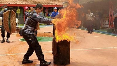 Pegawai Lapas Kelas II Tuban, mensimulasikan pemadaman api dengan menggunakan karung basah./tugu jatim