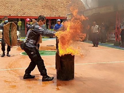 Pegawai Lapas Kelas II Tuban, mensimulasikan pemadaman api dengan menggunakan karung basah./tugu jatim