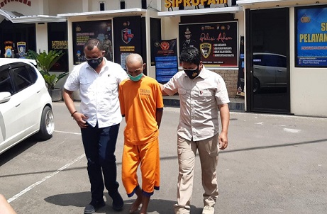 MK (61), tersangka pembunuhan istri di Kabupaten Malang dikawal polisi./tugu jatim