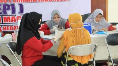 Petugas Kesehatan Polres Magetan menyuntikkan vaksin covid ke lansia peserta Serbuan Vaksin Merah Putih di PG Redjosari, Rabu (31/11/2021). (Foto: Wawan/Tugu Jatim)