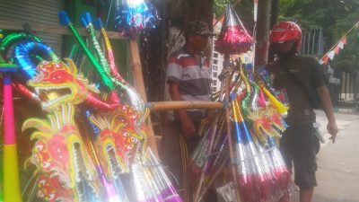 Penjual terompet tetap berjualan meski omzetnya menurun drastis.