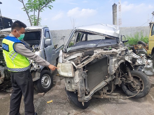 Polisi mengamankan minibus Suzuki Ertiga yang remuk setelah menabrak truk di tol Gempol, Pasuruan.