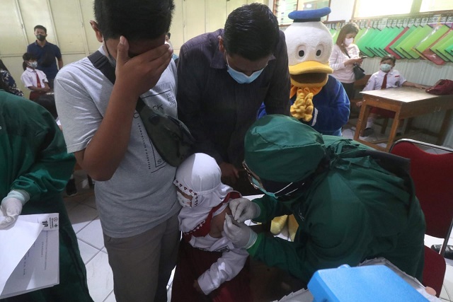 Wali Kota Kediri, Abdullah Abu Bakar, memegang Qafisha Malia Rahmadani yang ketakutan saat divaksin.