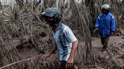 Dua orang warga berjalan di sekitar aliran lahar dingin Semeru