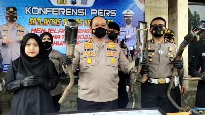 Polisi menunjukkan hasil sitaan knalpot brong dalam penertiban pengguna kendaraan di Kota Kediri, Rabu (8/11/2021)