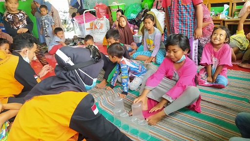 Anak-anak korban bencana banjir lahar dingin Gunung Semeru tertawa bahagia diajak bermain oleh rekan-rekan dari Jasuni Indonesia Malang di tempat pengungsian, Senin (6/12/2021).