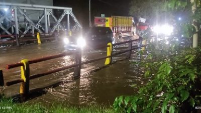 Banjir luapan sungai Petung menutupi jalur Pantura di Kota Pasuruan , MInggu (1/1/2022).