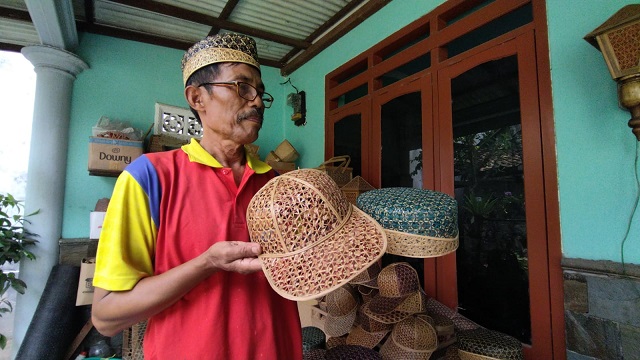 Imam Suhadi, pengrajin songkok bambu asal Kediri, menunjukkan karya anyamannya, Minggu (16/1/2022).
