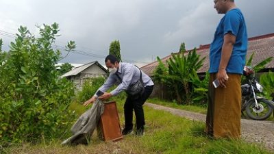 Kanit Reskrim Polsek Semanding, Iptu Mugianto, didampingi tokoh masyarakat, Ali Muhdi, mengamankan barang bukti kota amal