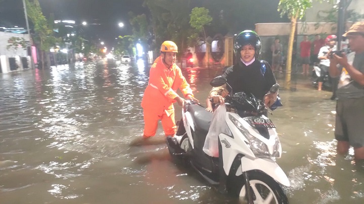 Tim BPBD Bojonegoro membantu evakuasi warga yang terjebak genangan air akibat curah hujan tinggi di jalanan Kota Bojonegoro, Selasa (15/02/2022) malam