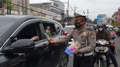 Polisi membagikan coklat kepada pengendara mobil di Kota Malang, Senin (14/2/2022).